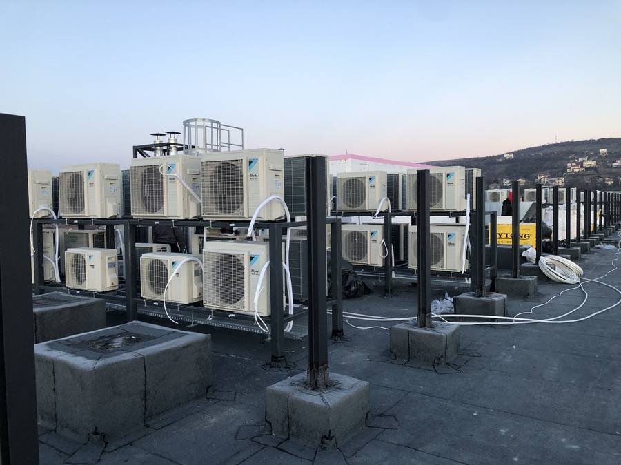 Zeci de unități exterioare Daikin montate pe structură metalică pe acoperiș