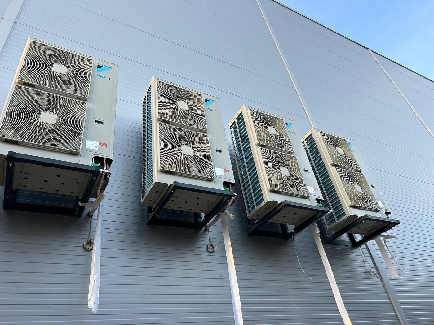 Patru unități exterioare Daikin VRV IV montate pe console pe fațada unei hale
